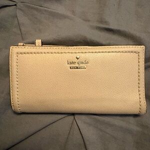kate spade “Staci”pebble leather zip-around wallet in taupe with gold logo